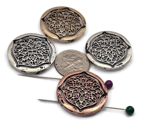 These round filigree 2‑hole slider beads add instant elegance to handmade jewelry. Featuring ornate lace‑style cutouts framed in antique silver, brass, and copper finishes, they make beautiful focals for bracelets, chokers, and pendant bars. Dual holes keep the bead flat and aligned. Perfect for boho, vintage, and Art Nouveau designs that call for lightweight dimension and timeless detail.