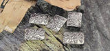 Leaf motif rectangle 2 hole beads, antique silver. The raised vine/branch artwork adds organic texture. Small dual holes keep the bead flat on fine materials—FireLine, Nymo, micro cord. Not for leather or chain. Great for minimalist bracelets, chokers, earrings, and rings. Five botanical slider beads included.