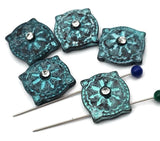 Bring handcrafted charm to your shop with textured patina slider beads. The weathered turquoise surface and starburst design surround a clear crystal for subtle sparkle. Two-hole construction delivers a clean, centered presentation. Ideal as focal beads in mixed‑metal, rustic, and boho collections. Reliable metal findings that photograph beautifully on white and lifestyle backgrounds. Each bead’s finish is uniquely varied.