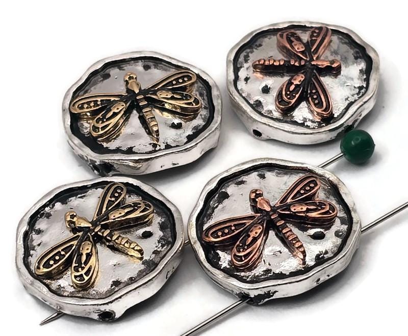 Dragonfly beads, 2 hole slider style, on rustic round coin settings. Antiqued silver backgrounds with raised copper or brass dragonflies. Textured edges and hammered surface add depth that photographs beautifully. Unique focal beads for bracelet designs and simple necklace pendants. Keywords: dragonfly bead, insect bead, nature bead, mixed metal slider bead, boho jewelry supplies, round coin bead.