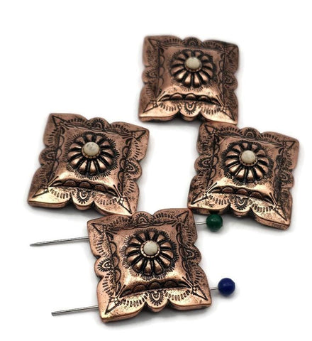 Western concho beads, 2 hole slider style, in warm antique copper. Square scalloped concho with engraved scrollwork and a domed rosette center accented by a cream cabochon. Unique focal beads for bracelet designs and simple pendant centers on necklaces. Keywords: concho bead, copper concho slider, western jewelry supplies, boho southwestern bead, floral concho focal.