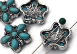 Turquoise floral 2 hole slider beads in vintage silver. Six petal cabochons with natural matrix surround a smooth button center, highlighted by beaded borders. Designed to sit centered for clean lines in finished pieces. A striking focal bead with western, rodeo, and desert‑boho personality for bracelets, necklaces, and statement earrings.