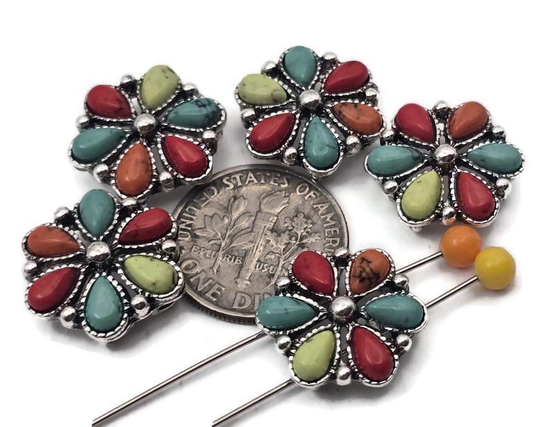 Southwestern flower 2-hole slider beads with multicolor turquoise-look petals. These concho-style metal beads make perfect focal beads for bracelets, hatbands, and chokers. Dual holes keep two strands aligned—ideal for leather cuffs, loom bands, and peyote strips. Use as spacer beads or statement findings in Western jewelry. Colors pop against antique silver, delivering instant rodeo and festival flair.