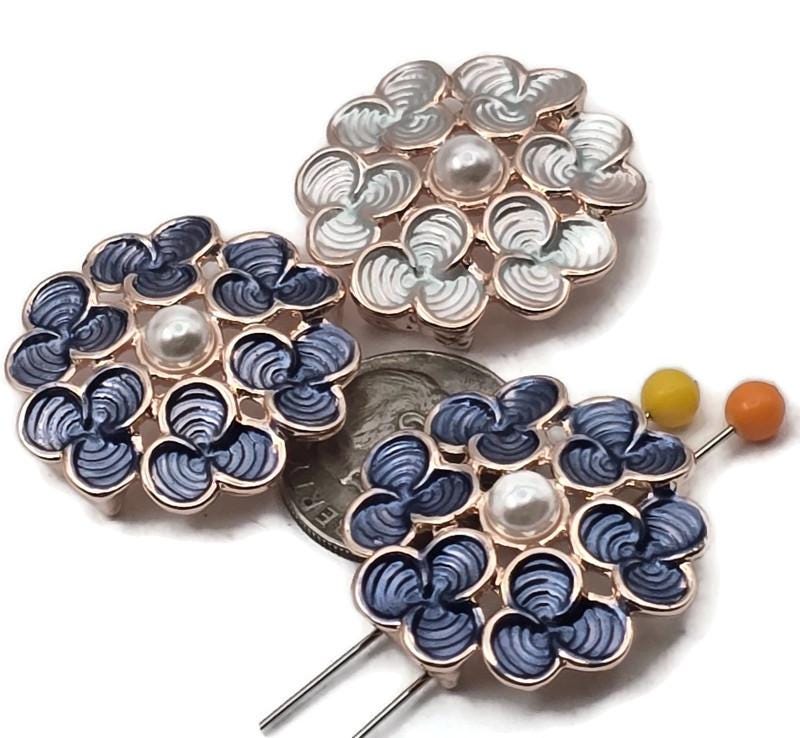 Bright gold 2 hole slider beads bloom with floral petals, glossy enamel in blue and light blue, and a faux pearl center. The double holes and back guide loops keep strands aligned for clean bracelet, pendant, and earring designs. Use as slider, spacer, or connector focal in bead weaving or stringing. Pair with seed beads to frame the flower. Lead and nickel compliant metal beads; also called two hole slide beads.