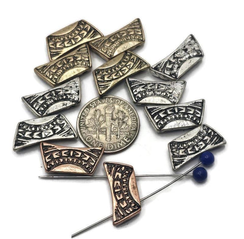 Curved rectangle 2‑hole slider beads with tribal‑style carvings. Mixed metals—antique silver, warm brass, and copper—highlight the texture. True double‑strand components: two small parallel holes keep thin strands aligned and flat. Ideal focal beads for cuffs, chokers, and pendant bars. Great for boho jewelry, southwestern designs, and festival stacks. Best with fine beading wire, FireLine, or micro cord (not leather/chain).