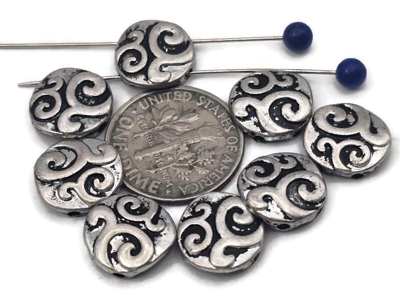 Round coin 2‑hole slider beads with bold swirl engraving in antique silver. Oxidized recesses make the pattern pop, giving bracelets a classic Celtic/boho vibe. Use as bracelet centerpiece, spacer bar, or pendant bar charm for layered chokers. Great fillers for stackable sets, bead‑loom cuffs, and men’s/unisex designs. Mix with onyx, hematite, turquoise howlite, or crystal for photo‑ready jewelry.