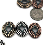 Sculpted sunburst ovals make bold coin beads for double‑strand bracelets. The marquise opening adds dimension while the verdigris wash pops against oxidized silver, brass, and copper. Use as structured spacer bars, strand separators in bead‑loom cuffs, or horizontal pendant connectors. Perfect for boho jewelry supplies and southwestern accessories.