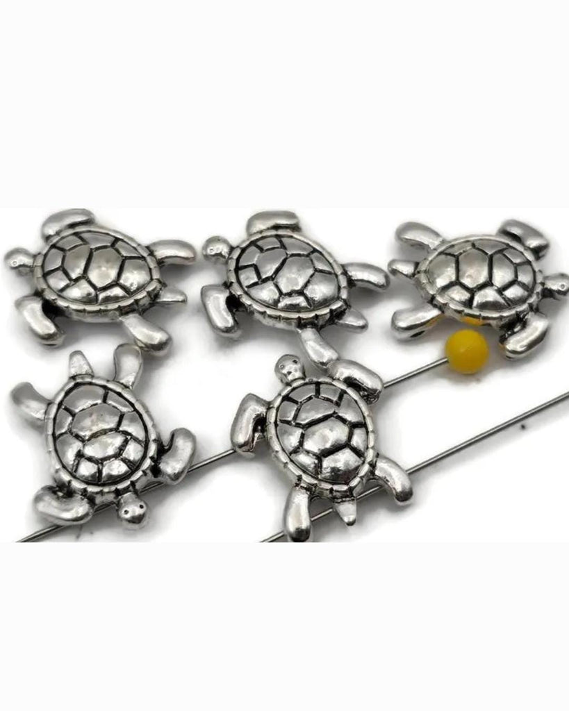 These silver sea turtle 2‑hole slider beads are perfect for double‑strand bracelets and chokers. Each bead features a raised, detailed shell and smooth finish, bringing coastal charm to boho or nautical jewelry designs. Their balanced structure keeps strands aligned, making them ideal spacers, focal beads, or connectors in artisan, beach, and ocean‑inspired creations.
