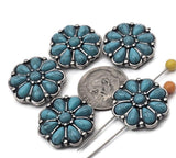 Turquoise concho flower 2‑hole slider beads for bracelets and hatbands. Each metal bead features teardrop petals encircled by dotted silver. Dual holes prevent twisting and keep patterns centered. Use as focal beads in leather, seed‑bead bands, and gemstone strands; or as large spacer beads in western necklaces. Reliable findings for DIY jewelry makers and teachers.