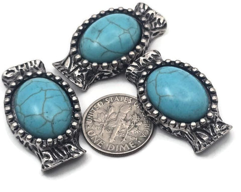 Western-inspired 2 hole slider beads in silver metal feature oval faux turquoise cabochons framed by concho-style texture. The double holes and central guide loops keep strands aligned, making these metal beads perfect as focal sliders or spacers for bracelets, necklaces, earrings, and wire-wrapped pendants. Use with seed beads or other favorites to design standout jewelry. Lead and nickel compliant beading components; also called two hole slide beads and connector beads.