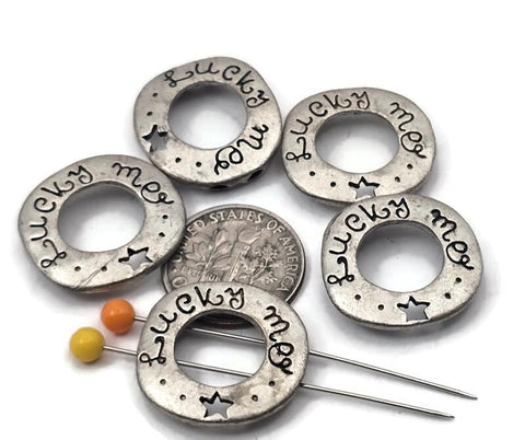 Light antique pewter 2 hole slider beads stamped “Lucky Me” with a cutout star make playful focals for jewelry making and crafting. Use these metal beads as slider focals, spacers, or connector components in a bracelet, necklace pendant, or earrings. Pair with seed beads, bugle, gemstone chips, crystals, pearls, Czech glass, or other metallic beads as fillers to build balance and texture. Versatile beading components and findings for DIY makers and small wholesale supplies.