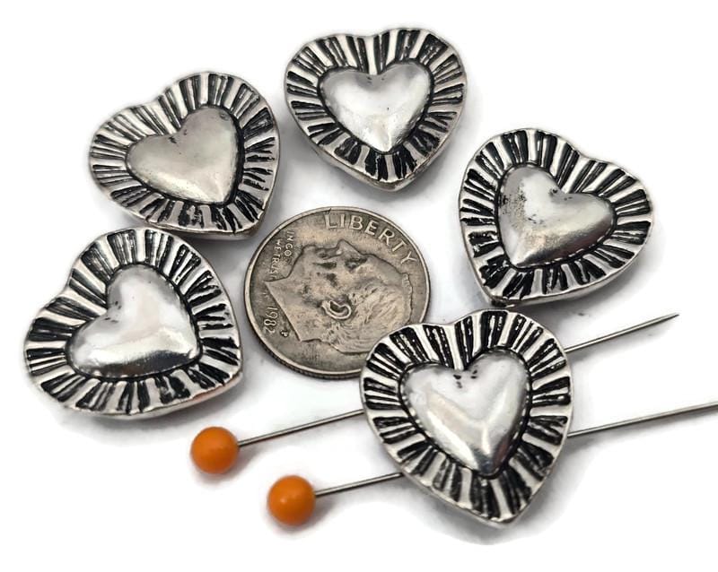 Silver heart 2 hole slider beads with a dimensional center and textured sunburst border. Use these metal beads as focal sliders, spacers, or connector components in bracelet stacks, chokers, and necklaces. Frame with seed beads as filler beads, then add crystals, pearls, or Czech glass for shimmer. Romantic beading components and findings for gifts, bridesmaid sets, friendship jewelry, and small‑batch wholesale. Lead and nickel compliant jewelry making supplies.