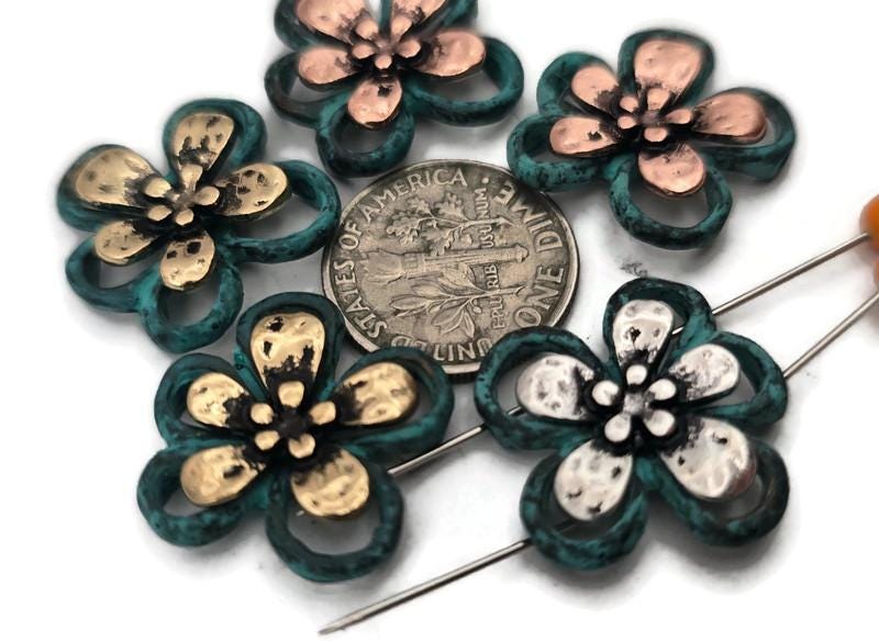 Patina flower 2 hole slider beads with open teal frames and domed metal petals in antique silver, gold, and copper. Use as focal sliders, spacers, or connector components in bracelets, chokers, necklaces, and earrings. Frame with seed beads as filler beads; add pearls, crystals, or Czech glass for shimmer. Essential metal beads and jewelry findings for boho, tropical, and spring collections. Lead and nickel compliant supplies for DIY makers and small‑batch wholesale.