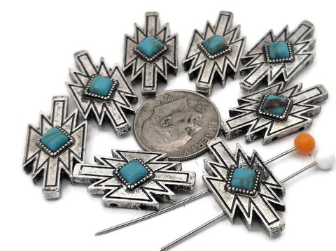 These Southwestern lightning bolt 2 hole slider beads feature a turquoise‑style center set in a bold silver‑tone geometric design. The double‑hole construction keeps two strands aligned, making them perfect focal beads for leather bracelets, chokers, and hatbands. Pair with seed beads, Czech beads, heishi, or gemstone chips for striking Western jewelry. Durable metal bracelet beads and jewelry making components for boho, rodeo, and tribal‑inspired designs.