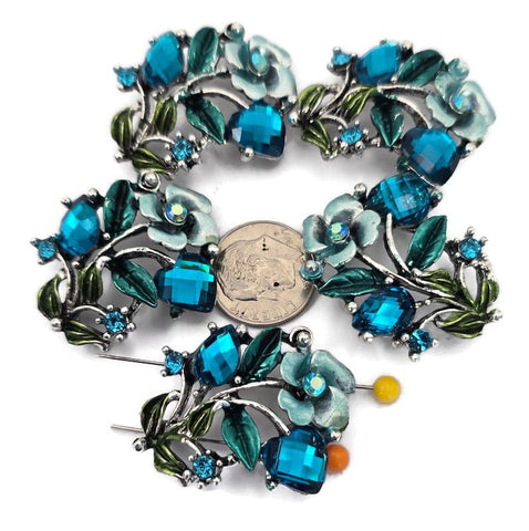 These ornate 2 hole slider beads feature large faceted blue zircon cube stones, smaller blue zircon accents, and decorative enamel leaf details in teal and green tones. Perfect as focal beads for bracelets and chokers, the double‑hole design keeps two strands of leather, cord, or beading wire aligned and centered. Pair with seed beads, Czech beads, and crystal accents for glamorous designs. Beautiful bracelet beads and jewelry making components for boho and statement jewelry.