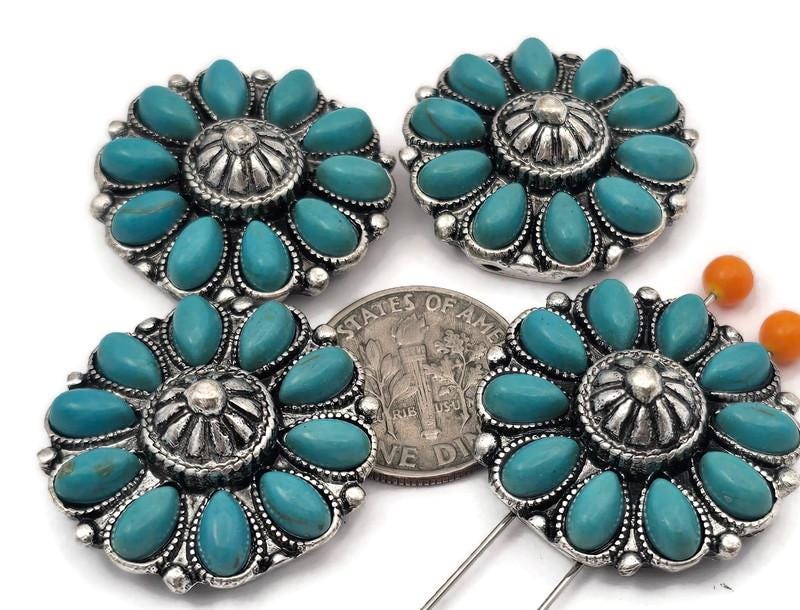 These Southwestern concho‑style 2 hole slider beads feature a floral design with turquoise‑style stones set in an ornate silver‑tone frame. The double‑hole construction keeps two strands aligned, making them perfect focal beads for leather bracelets, chokers, and hatbands. Pair with seed beads, Czech beads, heishi, or gemstone chips for bold Western designs. Excellent bracelet beads and jewelry making components for boho and Southwest‑inspired beading projects.