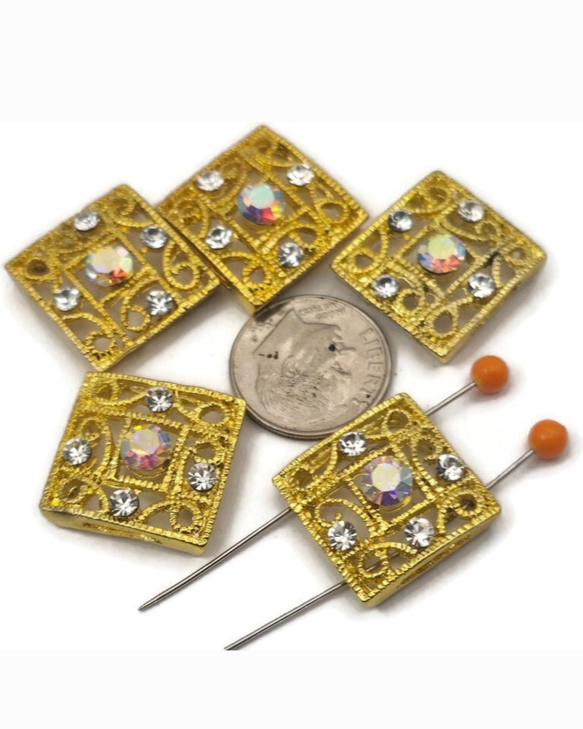 Add high-end sparkle to your jewelry with these gold 2-hole slider beads featuring an intricate filigree design. Each bead is accented with shimmering clear rhinestones and a brilliant clear AB center crystal that reflects a rainbow of colors. Perfect as focal beads for multi-strand bracelets or necklaces, these metal beads keep your strands aligned and secure. Ideal for beading, crafting, and creating elegant, boutique-style handmade jewelry.