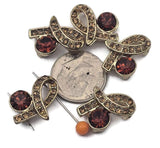 These glamorous gold ribbon slider beads are perfect focal beads for bracelets and necklaces. Featuring a sculpted bow shape with sparkling rhinestone accents and a large smoky topaz / amber‑brown crystal, they add instant elegance to any beading project. The 2‑hole connector design stabilizes double‑strand layouts and prevents twisting. Mix with seed beads, crystal rondelles, or gemstone spacers for boutique‑style jewelry making and crafting.