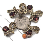 Create statement jewelry with these gold 2‑hole focal slider beads. The ornate ribbon design is set with a large smoked topaz (deep cognac) crystal and shimmering champagne rhinestones for warm, dramatic sparkle. Use as bracelet connectors or centerpiece beads in multi‑strand necklaces. Their two holes help keep strands tidy and evenly spaced. Perfect with seed beads, pearls, gemstones, and rhinestone spacers for DIY beading and jewelry supplies.