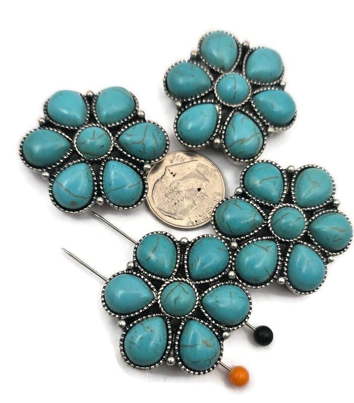 These Western turquoise floral 2 hole slider beads feature multiple turquoise‑style cabochons arranged in a bold flower pattern with silver‑tone metal detailing. Perfect as focal beads for bracelets and chokers, the double‑hole design keeps two strands of leather, cord, or beading wire aligned and centered. Pair with seed beads, Czech beads, heishi, or gemstone chips for striking Southwestern designs. Beautiful bracelet beads and jewelry making components for boho and Western jewelry.
