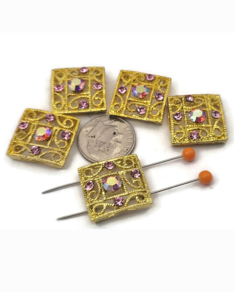 Add instant sparkle to bracelets and necklaces with these gold 2‑hole slider beads featuring an elegant filigree design and dazzling rose rhinestone crystals. The center stone has a brilliant AB coating for rainbow flash and high‑end shine. Use these metal focal beads as connectors in multi‑strand projects or as statement accents with seed beads, gemstone beads, and spacers. Perfect jewelry making supplies for glamorous, feminine designs.