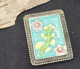 Capture a vintage vibe with this unique 2-hole focal slider bead. Featuring a soft aqua enamel finish and a romantic floral design, it is elegantly framed in antique silver metal. This large metal bead is designed to sit flat, making it an excellent connector for wide bracelets or chokers. Pair with gemstone beads or rhinestones to create sophisticated, light-catching jewelry. Perfect for beading, DIY gifts, and professional jewelry design.