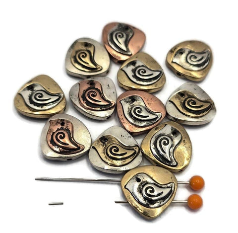 Add a touch of nature to your designs with these mixed‑metal bird beads. Featuring a stylized songbird motif with a graceful swirl wing, these teardrop‑shaped focal beads come in antiqued silver, gold, and copper tones. Perfect for jewelry making, they add artisan texture to bracelets and necklaces. Pair with seed beads, gemstone beads, or pearls for boho‑chic, nature‑inspired handmade jewelry and unique DIY gifts.
