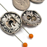 Create stunning beach jewelry with these sand dollar double strand slider beads. The raised center medallion features antique detailing with mixed metal tones that give the bead depth and character. The two hole design allows easy use with leather cord, wire, or beading thread. Perfect for coastal jewelry, ocean themed accessories, nautical bracelet designs, and sea life inspired handmade jewelry.