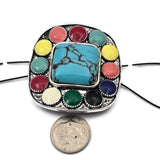 Create eye catching jewelry with this oversized western turquoise style focal bead. Measuring approximately 43 mm across, this two hole slider bead features a large center stone surrounded by colorful enamel accents in a detailed metal setting. Perfect for statement bracelets and necklaces using leather cord or beading wire. A beautiful choice for southwestern jewelry, cowgirl jewelry, and bold artisan jewelry designs.