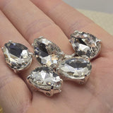 Clear rhinestone teardrop focal beads with silver prong setting, perfect for beaders and crafters. These 2 hole slider beads shine in wedding headpieces, bracelets, and multi-strand necklaces. Compatible with Duo, SuperDuo, and CzechMates two hole bead designs.
