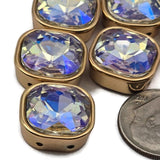 Faceted clear AB rhinestone double hole spacer beads in full gold bezel setting. These iridescent 2 hole slider beads are unique findings perfect for statement necklaces, layered bracelets, and bead weaving projects. Compatible with tile beads, carrier beads, and CzechMates components. A gorgeous aurora borealis focal bead for crafters and jewelry makers.