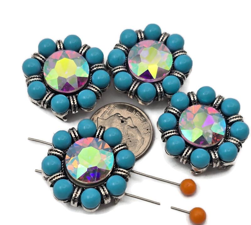 These 2 hole slider beads feature a sparkling AB crystal center surrounded by round turquoise colored beads in an antique silver setting. The faceted aurora borealis rhinestone reflects rainbow colors, creating a bold focal bead for jewelry designs. These metal slide spacer beads are perfect for two strand bracelet and necklace jewelry making and pair beautifully with seed beads, duo beads, gemstones, or leather cords for boho and western jewelry styles.