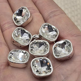 These clear rhinestone square 2 hole slider beads feature a brilliant faceted cut glass stone in a full platinum silver bezel setting. Stunning double hole spacer beads and unique findings for bridal jewelry, wedding accessories, and classic statement pieces. Perfect for bead weaving, stringing, and wire wrapping. Compatible with CzechMates, SuperDuo, tile beads, and other two hole bead designs.