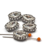 These encrusted border oval rhinestone 2 hole slider beads in platinum silver are rare hard to find focal beads for serious jewelry makers. Brilliant clear faceted center stone surrounded by sparkling border rhinestones. Perfect anchor point for bead weaving, peyote stitch, and loom work. Pair with turquoise, hematite, freshwater pearls, and seed beads for stunning finished pieces.