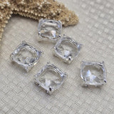Clear rhinestone square 2 hole slider beads in open back platinum silver prong setting, 12mm square, 6mm between holes. Lightweight resin rhinestone focal beads delivering brilliant sparkle without the weight of glass. Rare hard to find findings perfect for earrings, statement necklaces, and bead weaving anchor points. Pair with seed beads, freshwater pearls, hematite, and Czech glass. Unique rhinestone findings for beaders and jewelry designers.