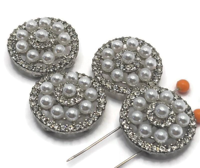 Elegant platinum silver 2 hole slider beads featuring a circular design with faux pearls and sparkling rhinestone pave accents. These metal beads are perfect for bracelet and necklace jewelry making, adding a luxurious vintage-inspired look. Pair with seed beads, duo beads, or crystal beads to create stunning designs for bridal jewelry, formal accessories, or high-end handcrafted pieces with timeless style.