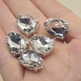 These clear rhinestone teardrop slider beads feature a brilliant cut glass crystal in a silver prong setting. Perfect double hole spacer beads for bridal jewelry, wedding headpieces, and custom veils. Use in bead weaving, peyote, wire wrapping, and stringing projects. Compatible with Duo, CzechMates, and other 2 hole bead designs. A unique focal bead for necklaces, bracelets, and earrings.