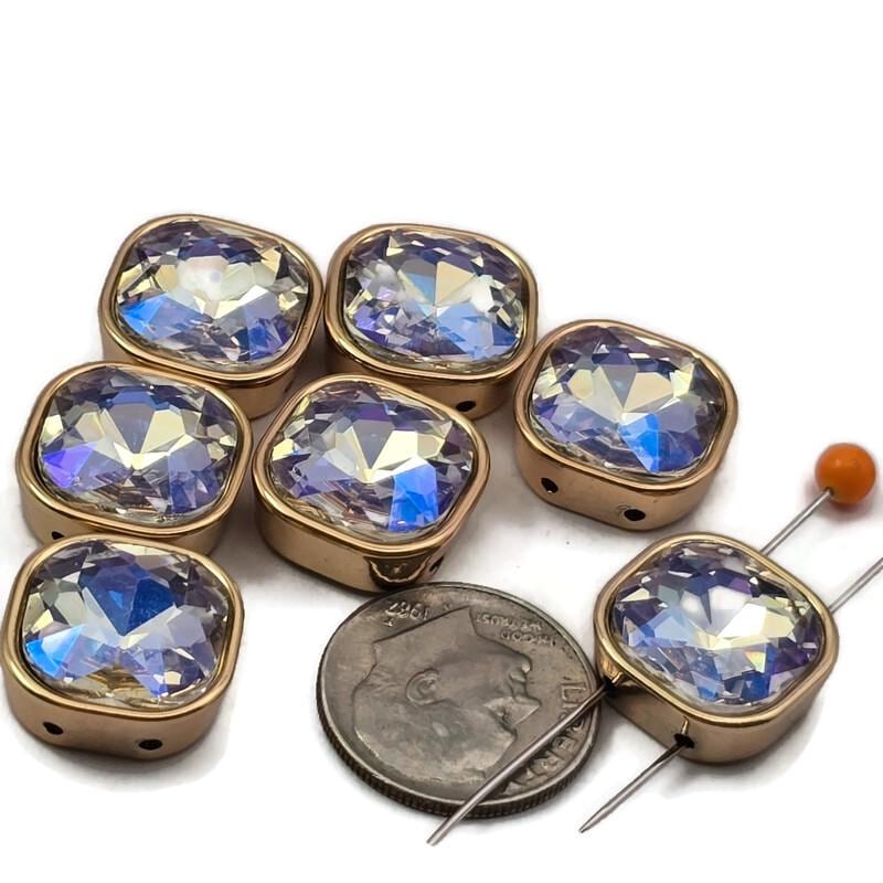 Aurora borealis square 2 hole spacer beads in gold bezel setting, flashing pink, blue, and purple in any light. These unique rhinestone findings work beautifully in layered necklaces, multi-strand bracelets, and bead weaving projects. Compatible with tile beads, CzechMates, and carrier beads. A stunning iridescent focal bead for beaders and crafters.