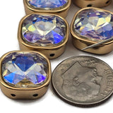 These square aurora borealis 2 hole slider beads feature color-shifting cut glass in a warm gold bezel setting. Beautiful unique findings for bohemian jewelry, festival accessories, and vintage-inspired designs. Perfect double hole spacer beads for stringing, wire wrapping, and bead weaving alongside CzechMates and SuperDuo components.