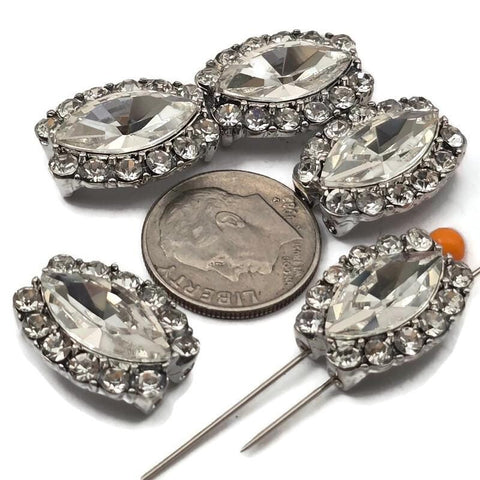 These clear rhinestone oval 2 hole slider beads feature a faceted center stone surrounded by an encrusted platinum silver border. Rare hard to find focal beads perfect for statement bracelets, pendant necklaces, and bead weaving anchor points. Pair with seed beads, turquoise, hematite, and Czech glass. Unique jewelry making findings for beaders and crafters seeking something truly special.