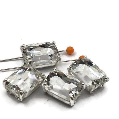 These clear rhinestone rectangle 2 hole slider beads feature a bold emerald cut stone in an open back platinum silver prong setting. Rare hard to find focal beads perfect for bridal necklaces, statement bracelets, and bead weaving projects. Anchor in peyote stitch or loom work, or pair with seed beads, turquoise, freshwater pearls, and Czech glass around them.