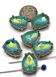 Six Seafoam Green AB pear-shaped 2 Hole Slider Beads with sparkling faceted rhinestones in polished gold settings displayed on a white background. The Aurora Borealis finish creates beautiful aqua blue, turquoise, lime, and seafoam green reflections. A dime and two beading needles provide size reference. These teardrop rhinestone slider beads feature dual stringing holes and are ideal for bracelets, necklaces, earrings, pendants, and bead weaving projects.