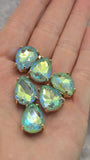 Seafoam Green AB pear-shaped rhinestone slider beads featuring brilliant faceted surfaces and polished gold settings. Six dual-hole beads are displayed on a white background with a dime and beading needles for size comparison. The Aurora Borealis finish produces colorful flashes of turquoise, aqua blue, lime, and seafoam green. These versatile 2 Hole Slider Beads are perfect for handmade jewelry, bead weaving, bracelet making, and necklace designs.