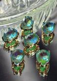 Six sparkling Seafoam AB rhinestone slider beads displayed with jewelry-making needles on a white background. The faceted pear-shaped rhinestones reflect vibrant shades of seafoam green, turquoise, aqua blue, and lime with every angle of light. Set in polished gold settings, these 2 Hole Slider Beads provide both elegance and versatility for bracelet making, necklace designs, pendants, keychains, and bead weaving creations.