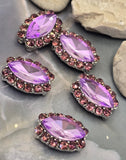 Five purple marquise 2 Hole Slider Beads displayed on a white background with a dime and beading pin for size comparison. Each bead features a faceted violet center stone framed by sparkling light amethyst rhinestones in polished silver-tone settings. These focal connectors work beautifully in handmade bracelets, necklaces, pendants, earrings, and bead weaving projects where colorful rhinestone accents and secure dual-hole construction are desired.