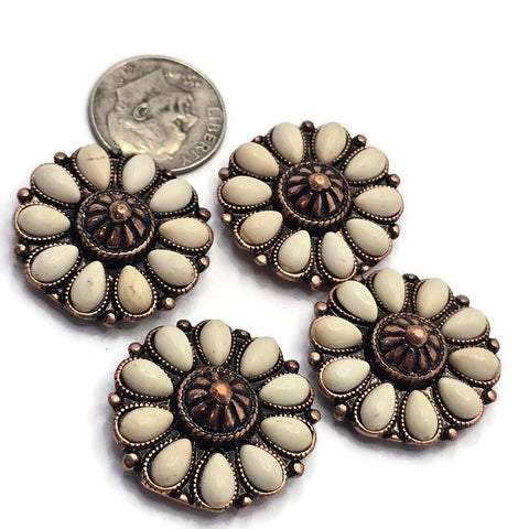 Flower-shaped 2 Hole Slider Beads featuring cream-colored faux stone accents arranged around a decorative antique copper center. Displayed beside a dime for size reference, these western-inspired focal beads combine warm copper tones with soft ivory coloring. Perfect for handmade bracelets, western necklaces, leather jewelry, artisan accessories, Southwestern designs, and custom jewelry making projects requiring decorative floral focal beads.