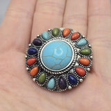 Western-inspired statement bead featuring vibrant turquoise blue, coral orange, olive green, deep blue, and purple faux stone accents arranged around a faux turquoise center. The antique silver metalwork highlights the colorful design and creates a rustic artisan appearance. This large focal bead works beautifully in handmade bracelets, necklaces, custom jewelry, and western-inspired fashion accessories.