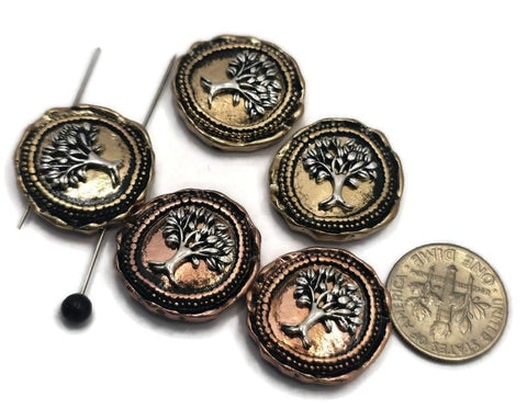 Round Tree of Life 2 Hole Slider Beads featuring raised Eternal Life Tree designs in mixed light antique gold and antique copper finishes. Displayed with a dime and beading pins for size reference, these symbolic focal beads are ideal for handmade bracelets, necklaces, spiritual jewelry, artisan accessories, family-themed designs, and meaningful jewelry making projects.