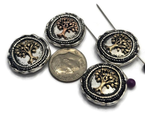 Round Tree of Life 2 Hole Slider Beads featuring raised tree designs in mixed antique copper and light antique gold finishes set against antique silver backgrounds. Displayed on a hand for size reference, these symbolic focal beads are perfect for handmade bracelets, necklaces, inspirational jewelry, family-themed accessories, artisan beadwork, and meaningful jewelry making projects.