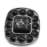 Bold western focal bead with faux marble detailing set in antique silver metal. The large center stone displays black coloring with contrasting white veining, while surrounding oval stones add dimension and texture. Dual holes allow for multi-strand jewelry construction. Shown with a dime for scale, this decorative slider bead works beautifully in bracelets, necklaces, leather jewelry, and artisan western jewelry projects.